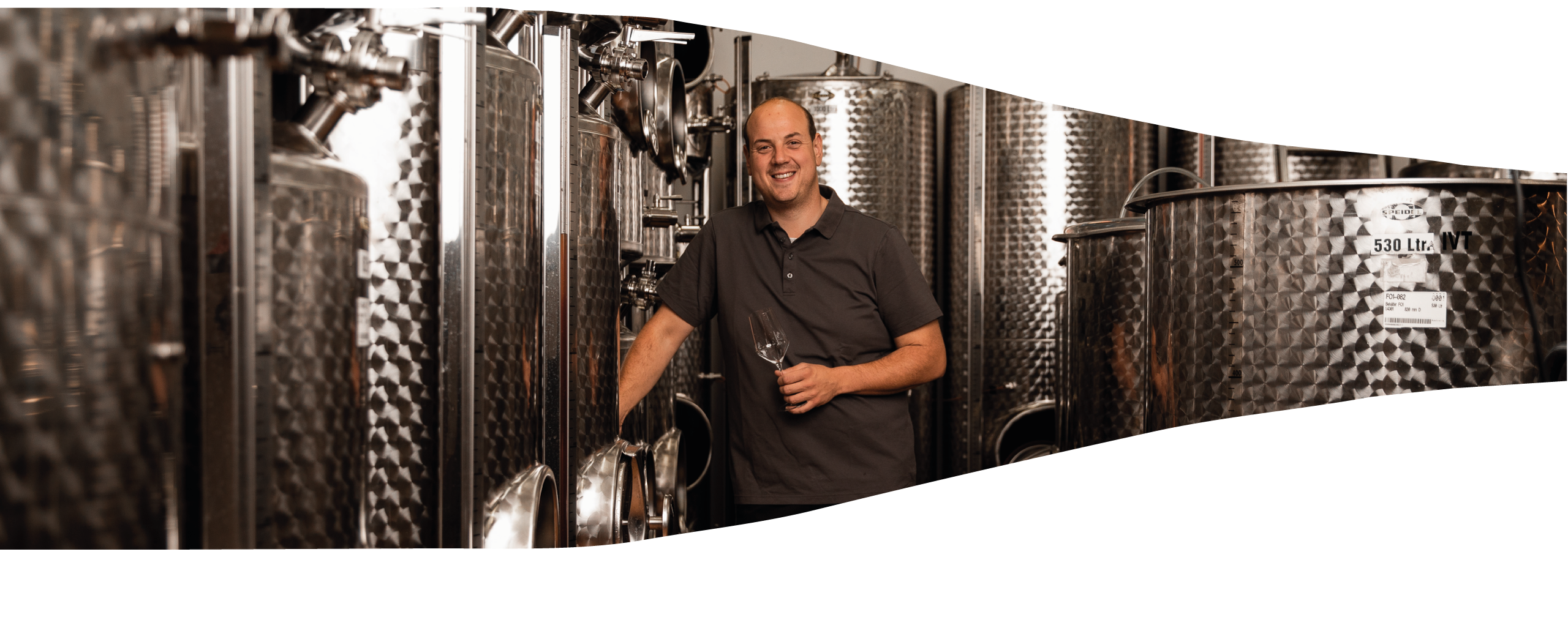 Bild als Weinflasche ausgeschnitten, Christoph posiert vor den Abfülltanks