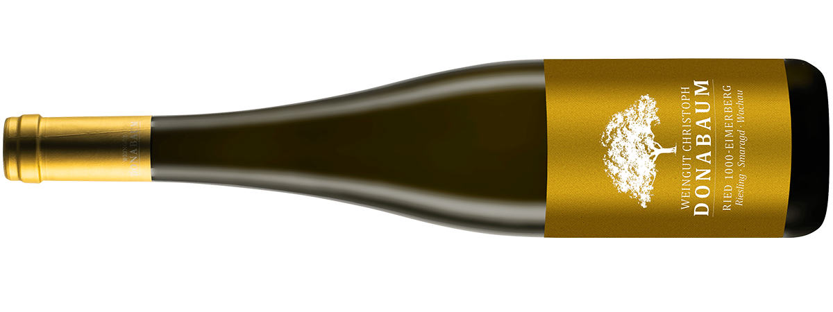 Liegende dunkle Weinflasche mit goldenem Etikett und weißem Logo darauf Riesling Smaragd Ried 1000 Eimerberg