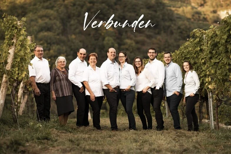 Familie_2 Text Verbunden steht über dem Foto von der Familie Donabaum im Weingarten
