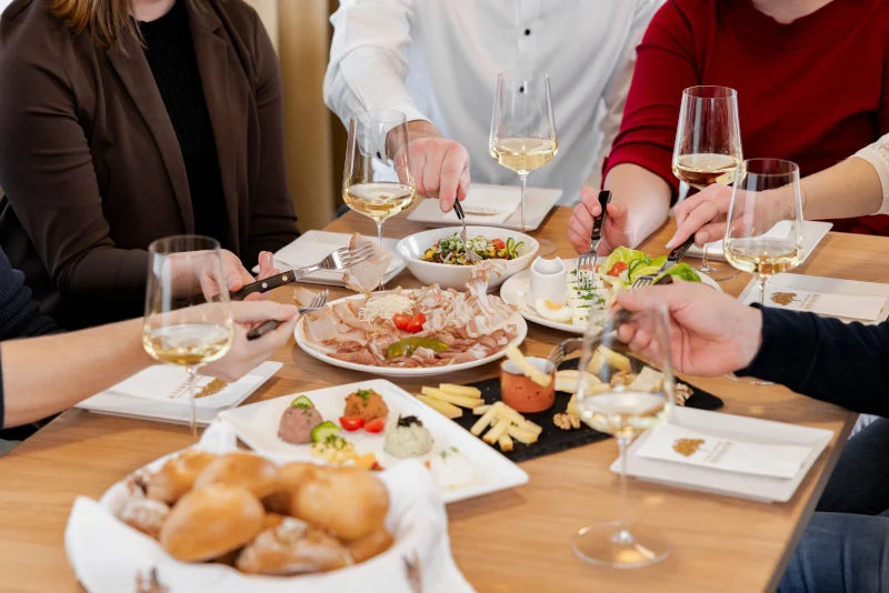 Ein gedeckter Tisch mit einer köstlichen Heurigenjause und Achterl Wein