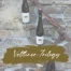 Three bottles of wine included in the package, with white or gold labels featuring a gold or white tree. The words “Veltliner Trilogy” are printed on the labels.